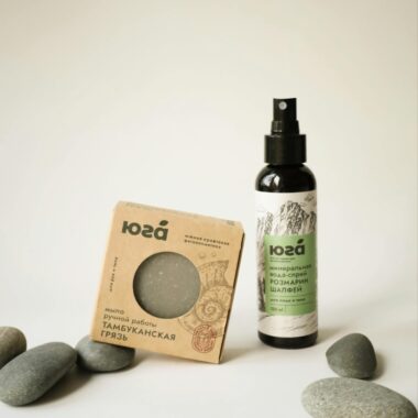 Elegant display of natural skincare products surrounded by smooth stones.