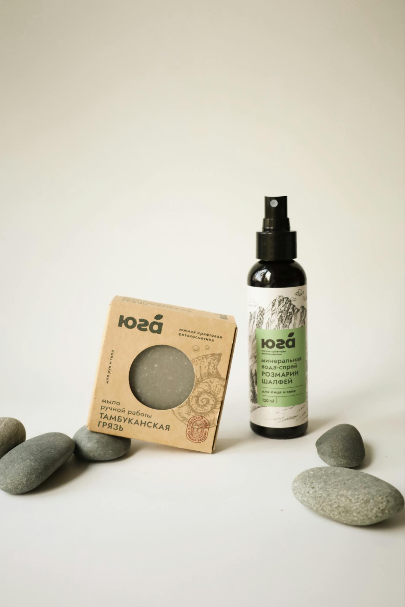 Elegant display of natural skincare products surrounded by smooth stones.