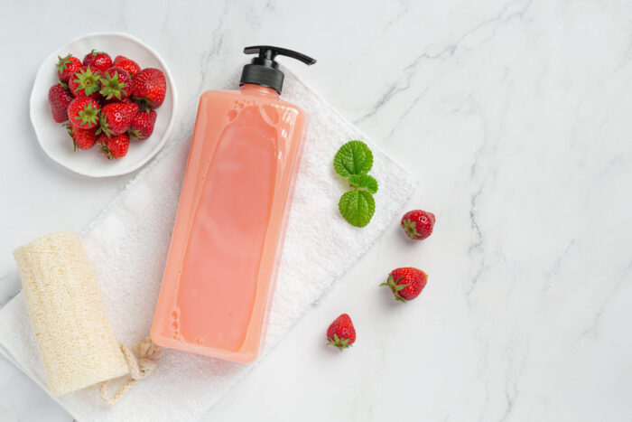 Cosmetic bottle strawberry shampoo on white backgroud