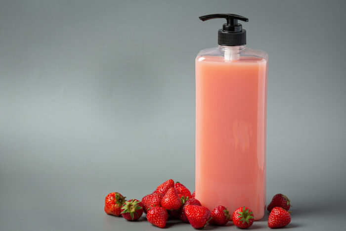 Cosmetic bottle strawberry shampoo on white backgroud