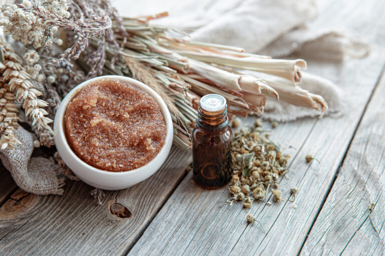 Close up of natural body scrub, oils and dry field herbs.